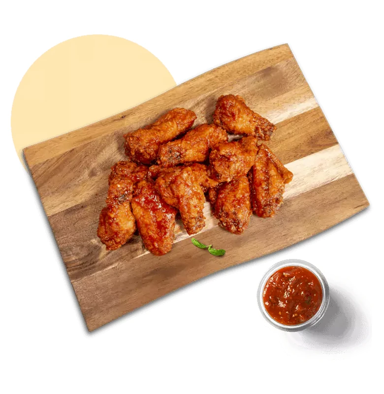 Crispy chicken wings served with marinara dip at Queen's Pizza & Wings in Hamilton, ON
